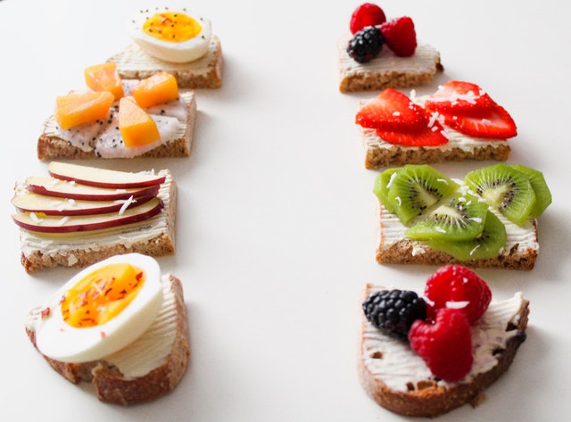 Celozrnné krajce chleba obložené rôznymi druhmi ovocia a vajíčkom
