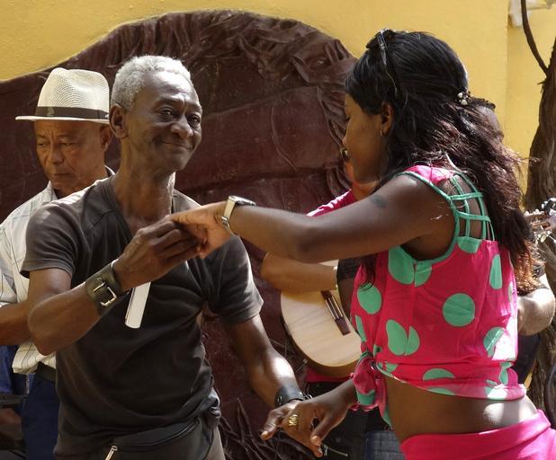 Starší muž a žena ho vyzýva k tancu, černosi
