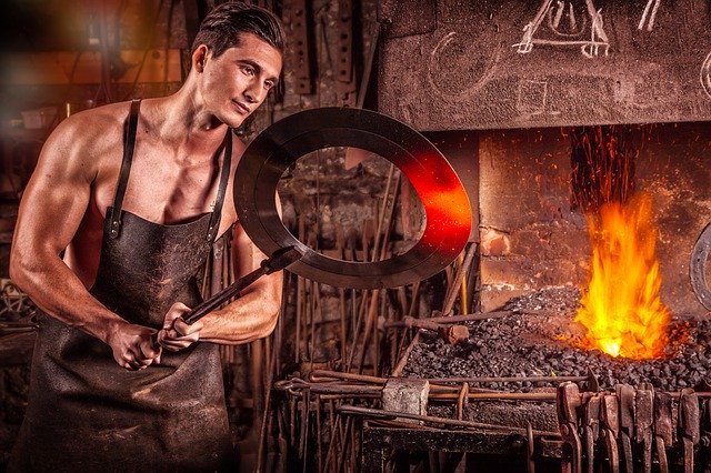 Muž vyberá z pece kus železa, ktorý kove.jpg